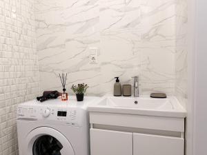 a white laundry room with a washing machine and a sink at Renthouse Apartments City Gates #5 in Chişinău
