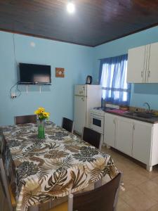 a kitchen with a table with a vase of flowers on it at Alojamiento Los Imigrantes in Chajarí