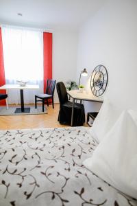 een slaapkamer met een bed en een tafel met stoelen bij zimmer-graz in Graz