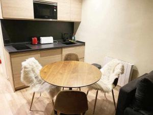 a kitchen with a table and two chairs with white fur at Nevada Home Lujoso apartamento a pie de pista in Sierra Nevada