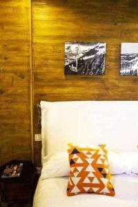 a bedroom with a bed with two pictures on the wall at Nevada Home Lujoso apartamento a pie de pista in Sierra Nevada