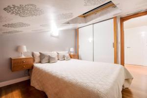 1 dormitorio con 1 cama con colcha blanca en Apartamento Ático San Juan by Clabao, en Logroño