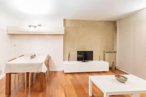 sala de estar con mesa blanca y TV en Apartamento Ático San Juan by Clabao, en Logroño