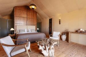 a bedroom with a bed and a glass table and chairs at Merzouga luxury desert camps in Merzouga