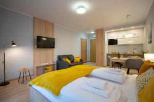 a bedroom with a large bed with a yellow blanket at RentPlanet - Studio Górna Resorts in Szklarska Poręba