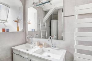 a white bathroom with a sink and a mirror at Apffel - Appt lumineux quartier Neustadt in Strasbourg