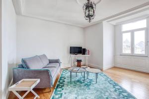 a living room with a couch and a table at Apffel - Appt lumineux quartier Neustadt in Strasbourg