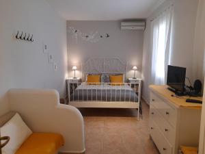 a small bedroom with a bed with yellow pillows at Aperi View in Karpathos Town