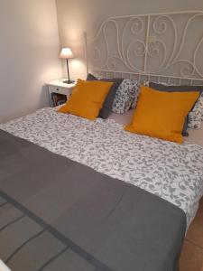 a large bed with two orange pillows on it at Aperi View in Karpathos