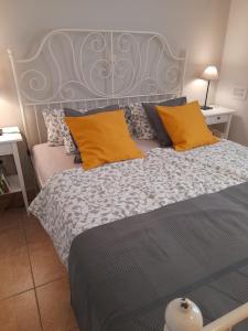 a bedroom with a large bed with orange and gray pillows at Aperi View in Karpathos