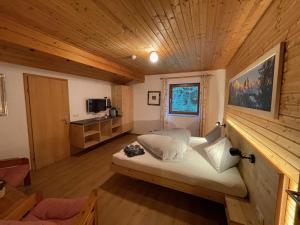 Garni Bärenwirt في لوتاش: غرفة نوم في كابينة خشب بها سرير