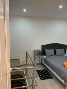 a bedroom with a bed and a table at Appartement en plein centre ville du bourget in Le Bourget