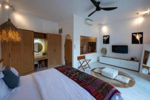 a bedroom with a large bed and a tv at Keramas Moonlight Villa in Keramas