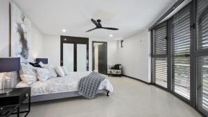 a bedroom with a bed and a ceiling fan at Riptides Booker Bay -Pay 2, Stay 3 nights this WINTER in Booker Bay