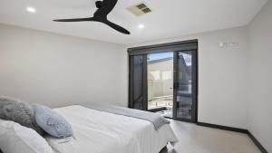 a bedroom with a bed and a ceiling fan at Riptides Booker Bay -Pay 2, Stay 3 nights this WINTER in Booker Bay