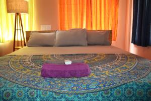 łóżko z fioletowym kocem na górze w obiekcie Da Mantra House w mieście Tiruvannamalai