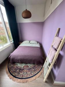 a purple bedroom with a bed and a rug at IVY - Classical & modern apartment in lovely neighbourhood near beach in The Hague