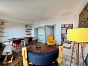 un salon avec une table et une chaise jaune dans l'établissement BergaNest, à Bergame