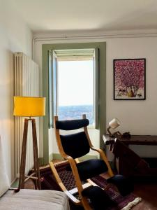 Cette chambre comprend une chaise, un bureau et une fenêtre. dans l'établissement BergaNest, à Bergame