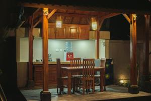 een keuken met een houten tafel en stoelen bij Villa Puri Kembar in Ubud