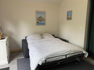 a bedroom with a bed with a white comforter at TAMA in Saint-Lunaire
