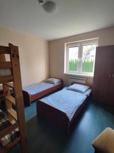 ミチュコフツェにあるNoclegi Pod Bukowinąのベッドルーム1室(ベッド2台、窓付)