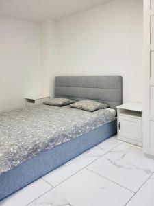1 dormitorio con cama y pared blanca en Stara Pošta Apartment 1, en Grosuplje