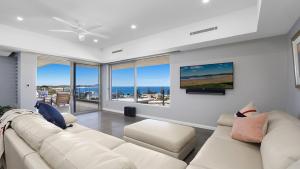 a living room with a white couch and a tv at Amazing Views and Short Walk To Beach in Terrigal