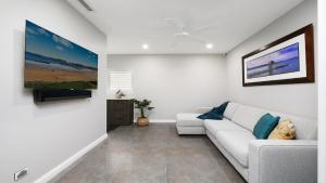 un soggiorno con un divano e una TV a parete di Amazing Views and Short Walk To Beach a Terrigal Altre 8 foto