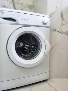 a white washing machine sitting in a room at Stara Pošta Apartment 1 in Grosuplje