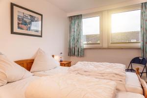 a bedroom with two beds and two windows at 50041 Muschelbank in Harlesiel