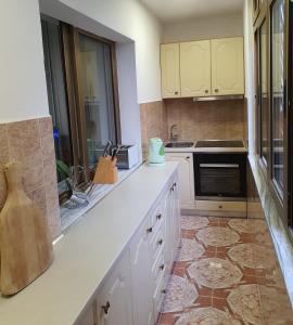 a kitchen with white cabinets and a tile floor at Central Home Away From Home in Shkodër
