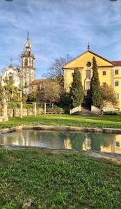 a large yellow building with a church and a pond at Casa da Venda in Ponte de Lima