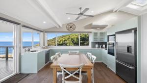 cocina con mesa y ventana grande en Beachviews at Killcare, en Killcare