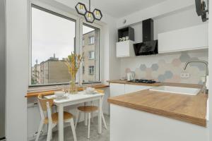 a kitchen with a sink and a table with chairs at Hetmańska Comfy Studio Poznań by Renters in Poznań
