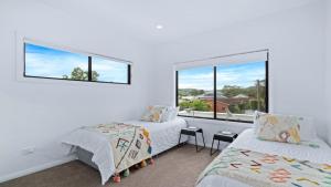 een slaapkamer met 2 bedden en een raam bij Bay Bliss U1 - Booker Bay in Booker Bay