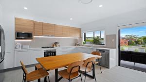 a kitchen with a wooden table and chairs in it at Bay Bliss U1 - Booker Bay in Booker Bay