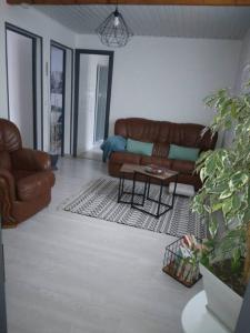 a living room with a couch and a table at Appartement Cosy avec Terrasse in Vaux-sur-Seine