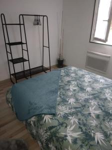 a bedroom with a bed with a blanket on it at Appartement Cosy avec Terrasse in Vaux-sur-Seine