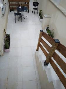a patio with a bench and a table and chairs at Appartement Cosy avec Terrasse in Vaux-sur-Seine