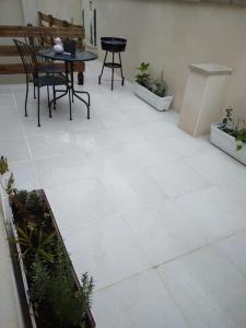 a white tile floor with a table and chairs at Appartement Cosy avec Terrasse in Vaux-sur-Seine