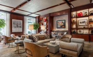 uma sala de estar com um sofá, cadeiras e mesas em Park Hyatt Chicago em Chicago