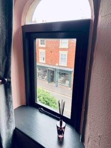 a window with a potted plant sitting on a table at Chapter Two - Melbourne in Melbourne