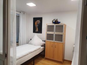 a small bedroom with a bed and a wooden cabinet at Ferienwohnung/Montagewohnung in Paderborn