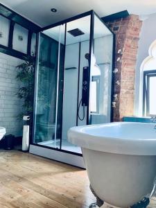 a bathroom with a white tub and a glass shower at Chapter Two - Melbourne in Melbourne +49 photos