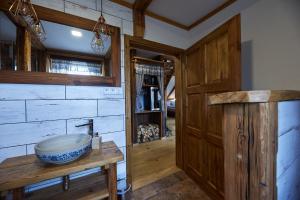 ein Badezimmer mit einem Waschbecken und einer Holzwand in der Unterkunft Božská usedlost in Prackov