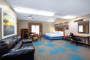 a hotel room with a couch and a bed at Days Inn by Wyndham Casper in Casper