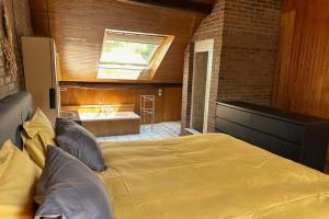 een slaapkamer met een groot bed en een badkamer bij Vakantiewoning Hoogveld in Kortessem