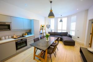 a kitchen and living room with a table and a couch at St Annes Beach Apartments in Lytham St Annes