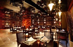 Wyndham Grand Plaza Royale Hangzhou في هانغتشو: مطعم بطاولات وكراسي وجدار من الطوب